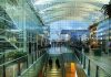Des lieux dHilton Munich Airport Lobby-corrigee passage qui ont une âme : aux voyageurs toujours entre deux avions, le Hilton Munich Airport offre, le temps d’une nuit, un cadre inspirant avec son immense structure en verre dessinée par Helmut Jahn.