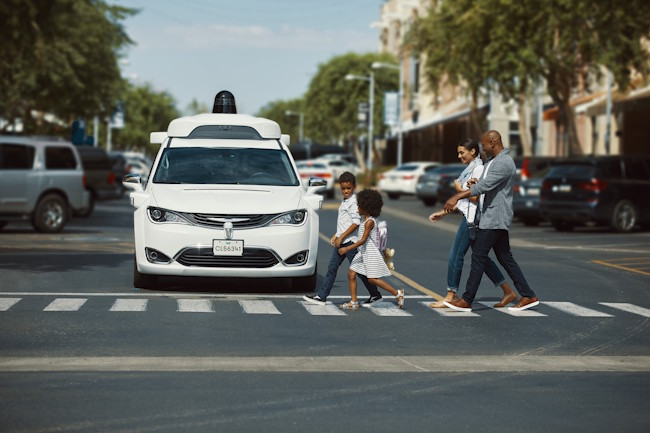 A Waymo self-driving taxi stopped at a pedestrian crossing in San Francisco.